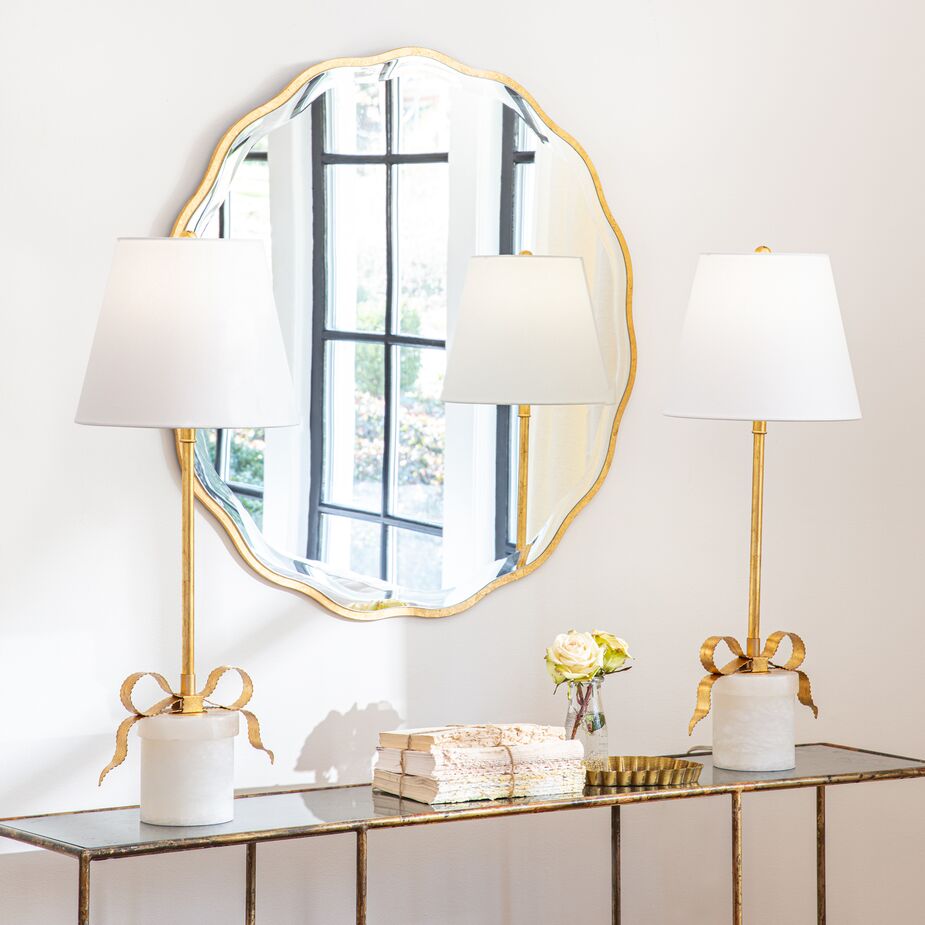 Not only does its shape add curves to the space, but the mirror reflects the outdoor space and the sunlight as well, opening up the room. The curves of the Ribbon Alabaster Table Lamps also help counter the numerous straight lines.
